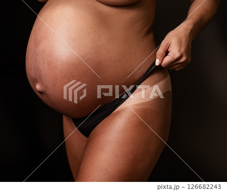 Pregnant woman pulls back her panties showing instant tan.  126682243
