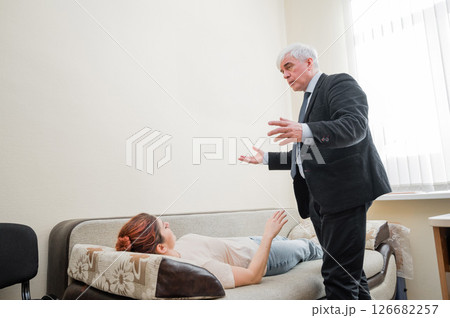 Elderly male hypnotherapist with a female patient. An alternative way to heal mental health Elderly male hypnotherapist with a female patient. An alternative way to heal mental health 126682257