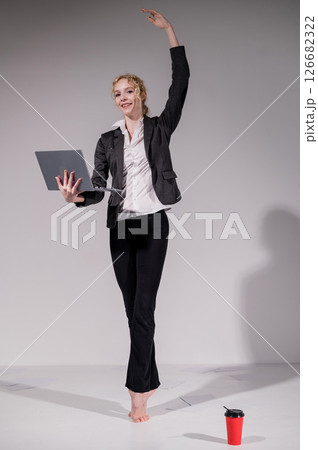Barefoot ballerina dancing in business suit on white background.  126682322