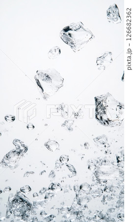 Ice cubes falling into water, creating bubbles, ripples, and a refreshing splash, perfect for illustrating concepts of coolness, purity, and hydration 126682362