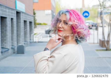 Close-up portrait of curly Caucasian woman with multi-colored hair. Model for hairstyles 126682470