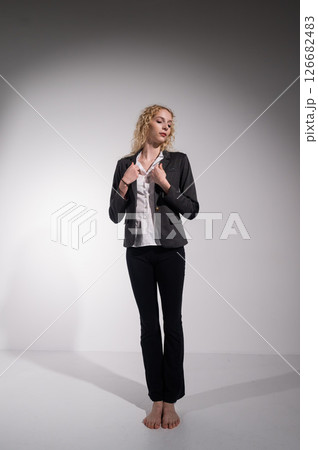 Barefoot ballerina dancing in business suit on white background.  126682483