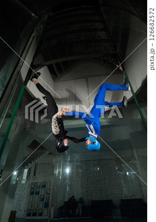 A man and a woman enjoy flying together in a wind tunnel. Free fall simulator A man and a woman enjoy flying together in a wind tunnel. Free fall simulator 126682572