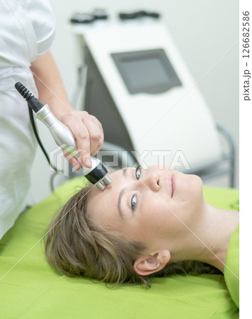Caucasian woman undergoing radio wave RF lifting procedure in beauty salon.  126682586