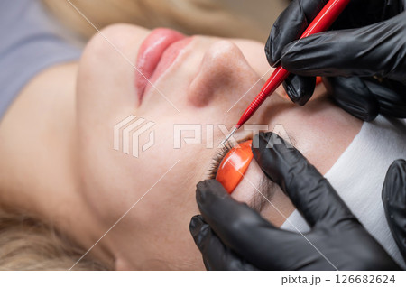 Caucasian woman undergoing eyelash lamination procedure. Caucasian woman undergoing eyelash lamination procedure. 126682624
