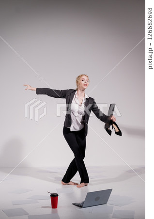 Barefoot ballerina dancing in business suit on white background. Barefoot ballerina dancing in business suit on white background. 126682698