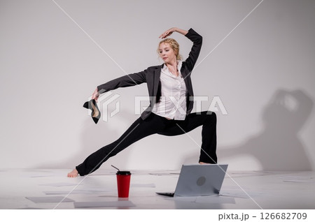 Barefoot ballerina dancing in business suit on white background. Barefoot ballerina dancing in business suit on white background. 126682709