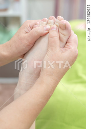Close up of a woman's foot being massaged. Close up of a woman's foot being massaged. 126682921