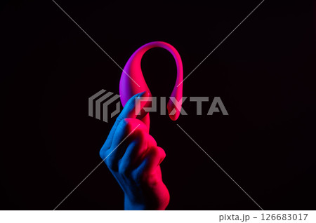 Woman holding a vibrator in neon pink and blue light. 126683017