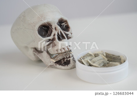 Skull Chewing Tobacco on a White Table. 126683044