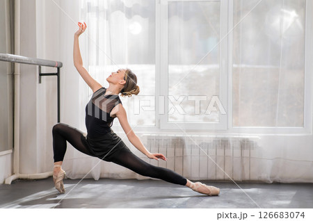 A beautiful Asian woman is dancing at the barre. Ballet dancer. 126683074