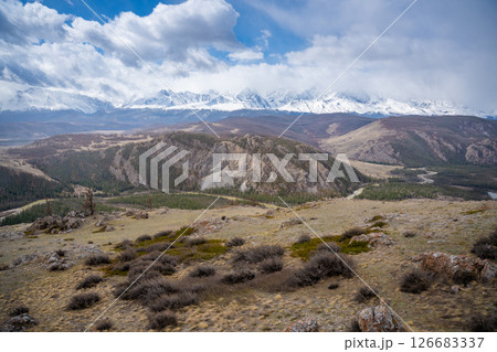 Panoramic view of Kurai Steppe with snow-covered North Chuysky Ridge in Altai Russia. Wide Siberian mountain landscape showcasing winter terrain and open plains. Panoramic view of Kurai Steppe with snow-covered North Chuysky Ridge in Altai Russia. Wide Siberian mountain landscape showcasing winter terrain and open plains. 126683337