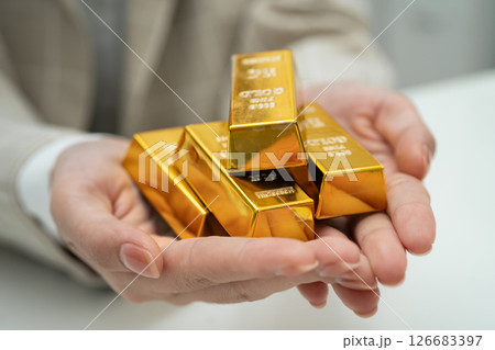 Asian woman holding gold bar in finance business. 126683397
