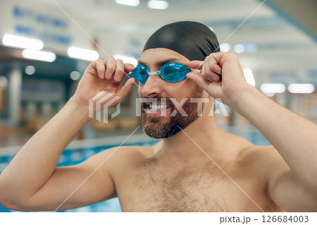 Confident bearded young caucasian man in the swimming pool Confident bearded young caucasian man in the swimming pool 126684003