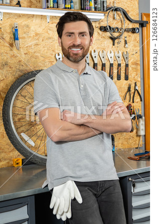 Mechanic standing with arms crossed in workshop Mechanic standing with arms crossed in workshop 126684123