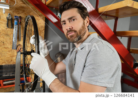 Mechanic in white gloves gripping wheel Mechanic in white gloves gripping wheel 126684141