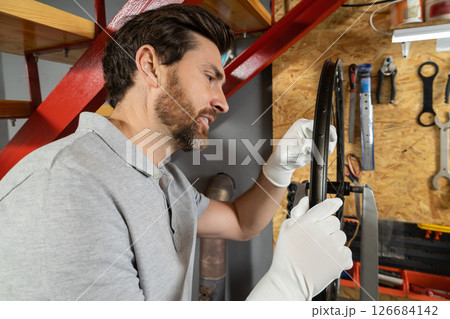 Mechanic in white gloves working on wheel Mechanic in white gloves working on wheel 126684142