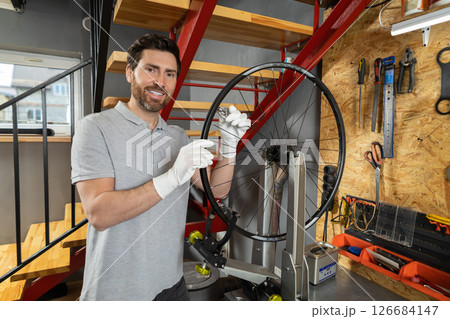 Mechanic in white gloves with wheel upright 126684147
