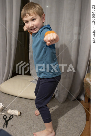 Young boy performing karate in living room 126684322