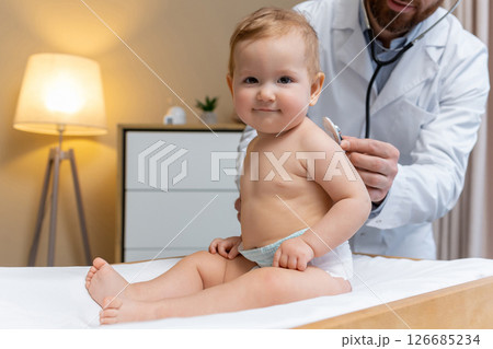 Doctor examining a cute little patient and looking concentrated 126685234