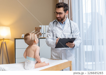 Pediatrician examining a cute little baby boy in his office Pediatrician examining a cute little baby boy in his office 126685265