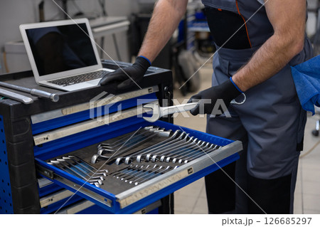 Mechanic working with tools and laptop 126685297