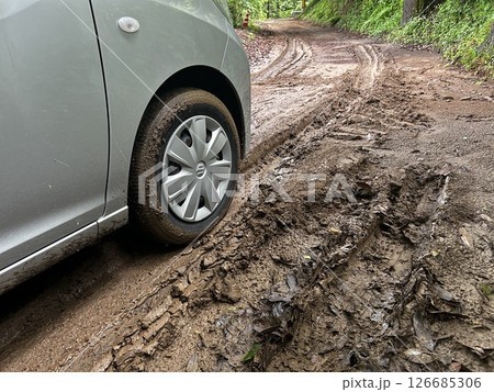 ぬかるみでスタックした乗用車の前輪タイヤの素材写真 126685306