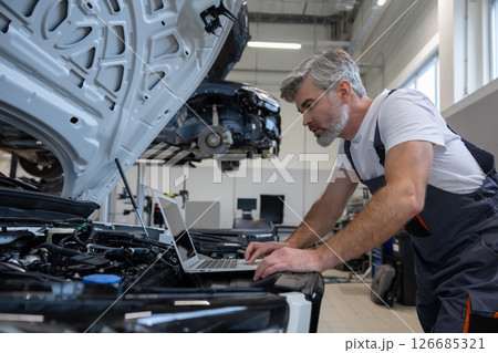 Mechanic with laptop in auto repair workshop Mechanic with laptop in auto repair workshop 126685321