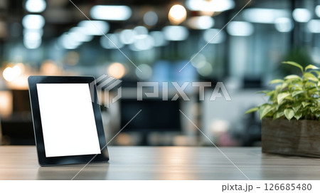 Tablet with white screen placed on desk in modern office setting, ideal for presentations or creative work 126685480