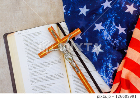24 April 2025 Washington DC US Bible open to passage sits next to crucifix, folded American flag, representing faith, patriotism 24 April 2025 Washington DC US Bible open to passage sits next to crucifix, folded American flag, representing faith, patriotism 126685991