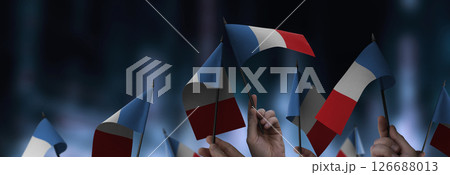 France flags in their hands on a blurred urban background 126688013