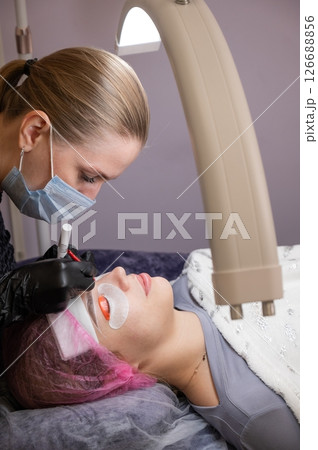 Caucasian woman undergoing eyelash lamination procedure.  126688856