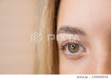 Close-up of a woman's eye after eyelash lamination procedure. Close-up of a woman's eye after eyelash lamination procedure. 126688930