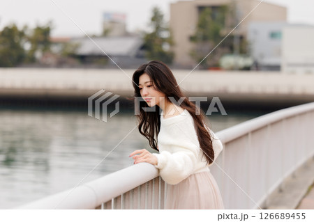 白い服着た若い女性が港でのんびりする 126689455