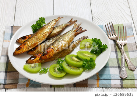 Hot smoked Baltic herrings with kiwi fruit slices 126689635