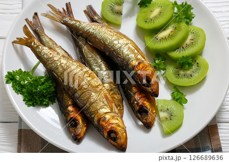 Hot smoked Baltic herrings with kiwi fruit slices Hot smoked Baltic herrings with kiwi fruit slices 126689636