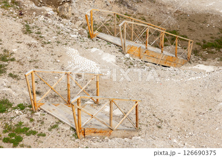 Wooden stair bridges traverse a rocky landscape Wooden stair bridges traverse a rocky landscape 126690375