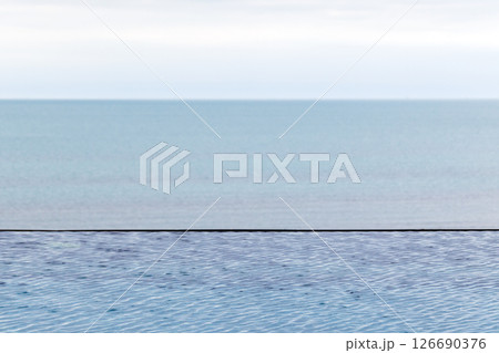 Infinity pool blending seamlessly with tranquil sea 126690376