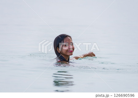 young asian woman enjoying swimming and smiling in shallow water of sea 126690596