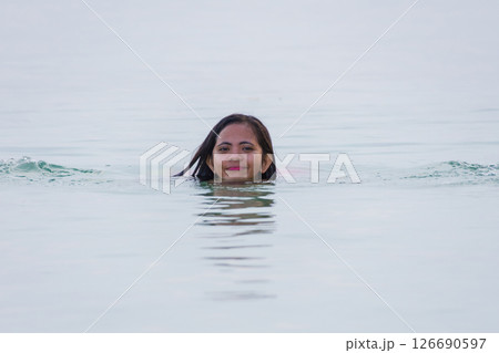young asian woman enjoying swimming and smiling in shallow water of sea 126690597