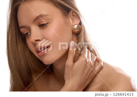 Glamorous woman in golden earrings looking into camera. Female model with soft natural makeup and glowing skin Glamorous woman in golden earrings looking into camera. Female model with soft natural makeup and glowing skin 126691415