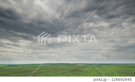A Vast and Expansive Green Landscape Beautifully Set Under Dramatic and Moody Clouds Above Time lapse. 126692648