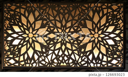 An artistic pattern cut into an MDF board is backlit, highlighting its precision and intricate details. An artistic pattern cut into an MDF board is backlit, highlighting its precision and intricate details. 126693023