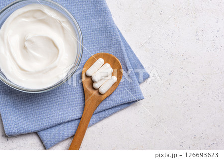 Probiotic capsules and bowl of yogurt 126693623