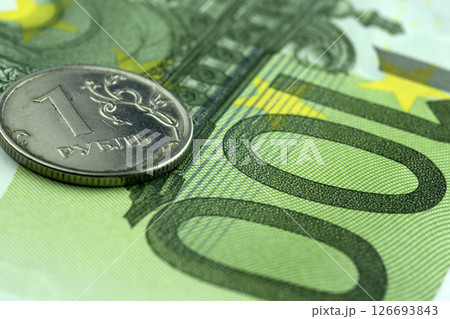 Russian coin of 1 ruble and 100 euro banknote, close-up. 126693843