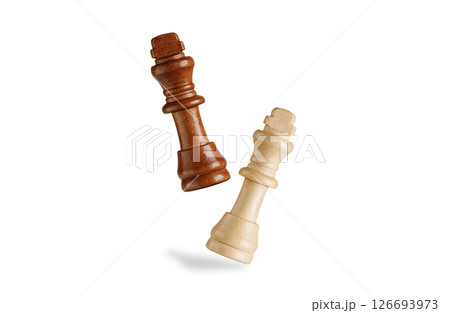 black wooden king chess piece with a falling white king in air on white backdrop. Perfect for strategy, triumph, and chess concepts. 126693973