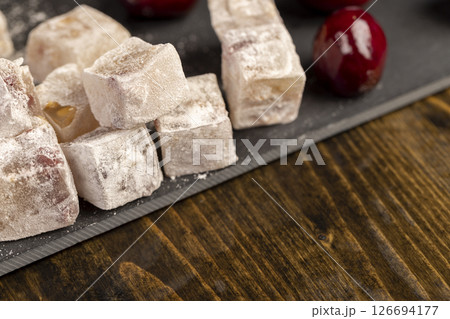 Turkish delight with cherry close up, cubes of sweet Turkish delight with dried red berries in powdered sugar Turkish delight with cherry close up, cubes of sweet Turkish delight with dried red berries in powdered sugar 126694177