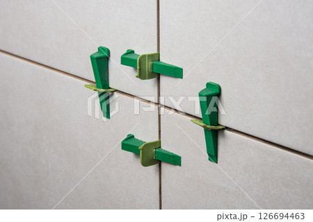 Tile leveling system with plastic clips and wedges, shot while the tile mortar sets Tile leveling system with plastic clips and wedges, shot while the tile mortar sets 126694463