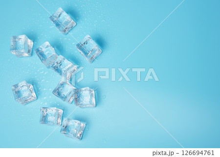 Ice cubes on blue with water drops background with copy space Ice cubes on blue with water drops background with copy space 126694761