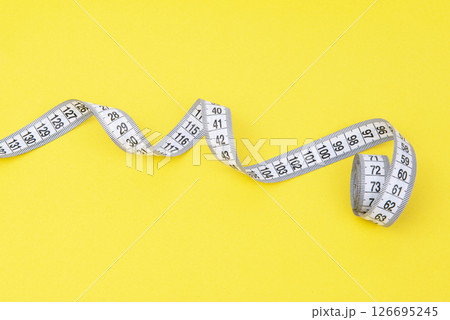 white tape measuring isolated on a yellow background white tape measuring isolated on a yellow background 126695245
